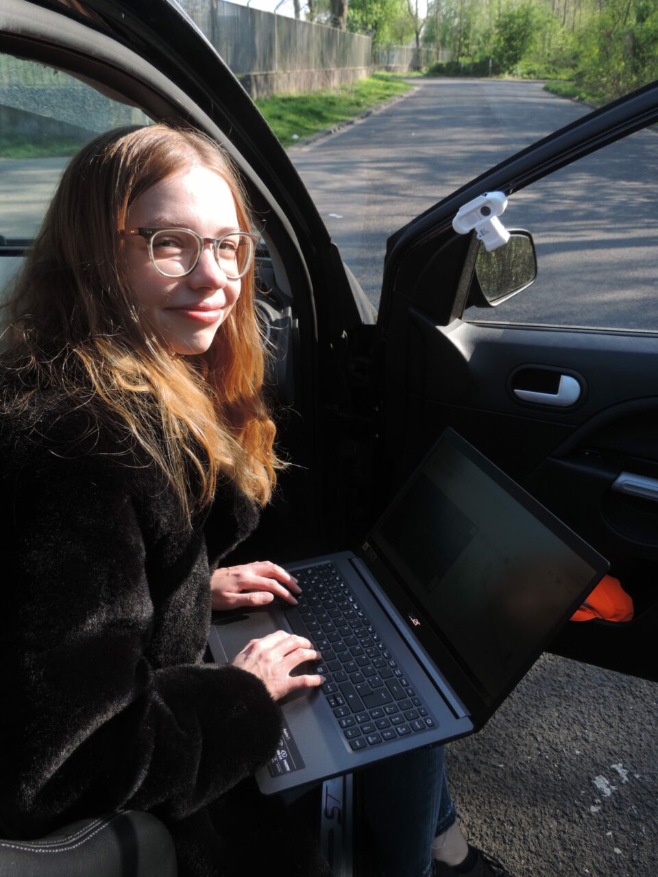 Sarah Wilke mit dem Laptop im Auto